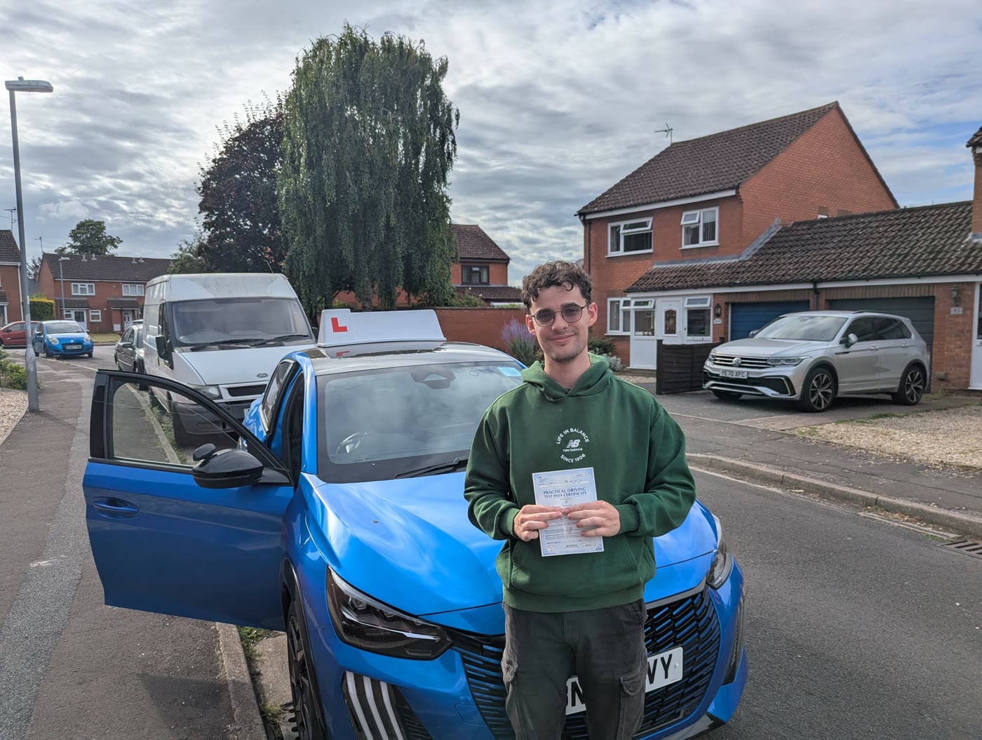 A smiling learner celebrates a driving test pass